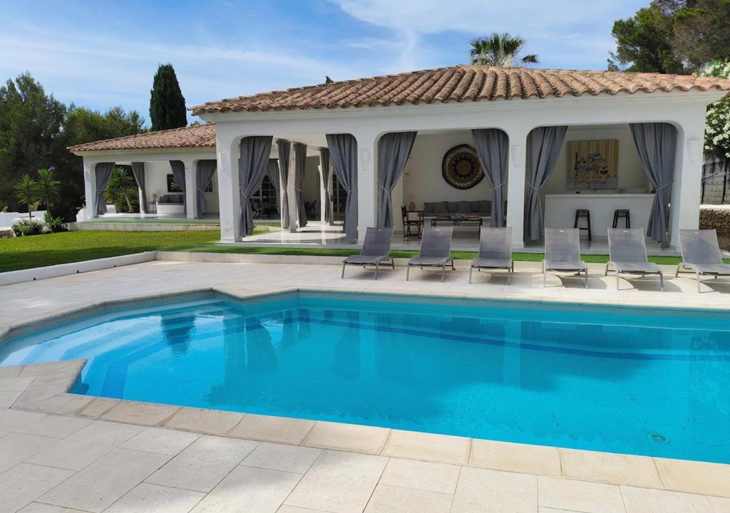 a swimming pool in front of a house with a gazebo at Menorca Villa Marbella in Son Parc