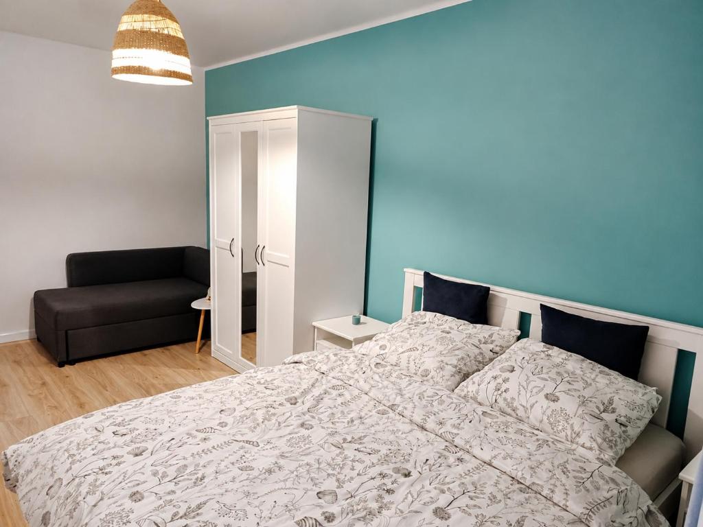 a bedroom with a bed and a black couch at Róża Wiatrów Leśny Klif 2 in Debina