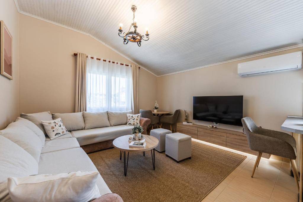 a living room with a couch and a tv at Loen Spacious Seaside Apartment 3BR Free Parking by PikHost in Durrës