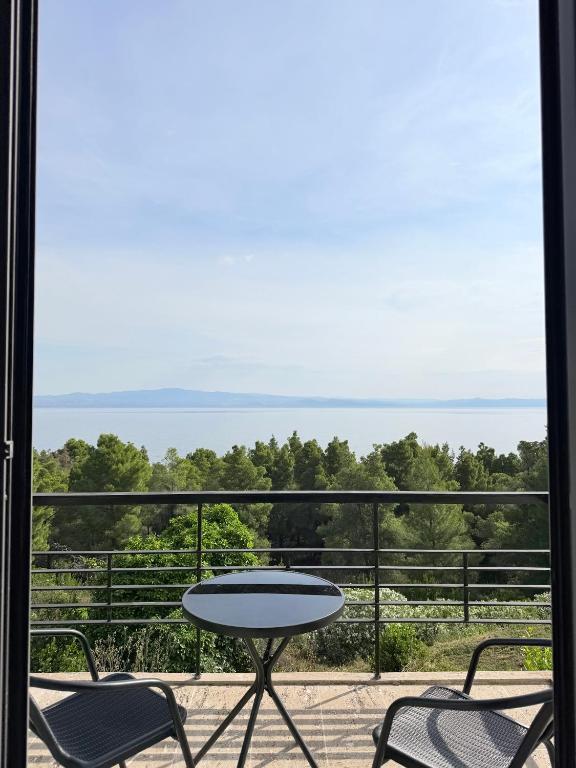 a table and chairs on a balcony with a view of the ocean at Afremar Estate in Nea Fokea