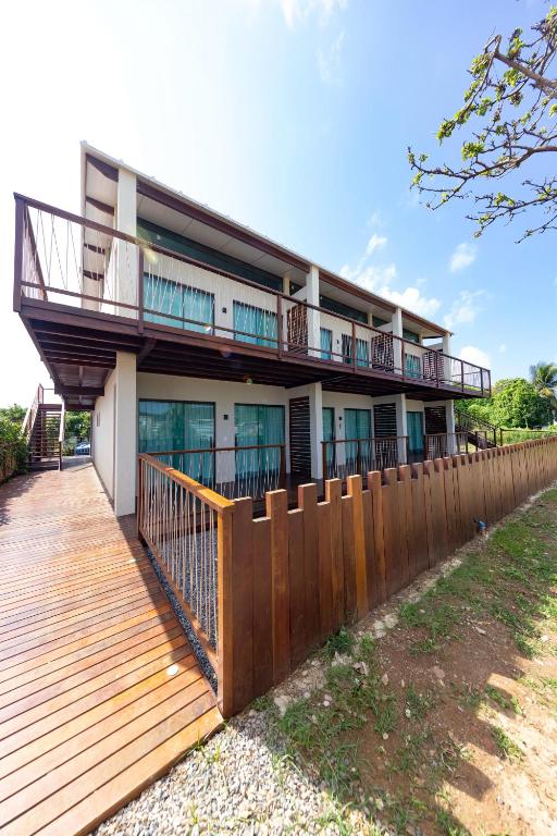 a house with a wooden deck and a fence at Flats do Cuca in Fernando de Noronha