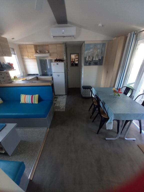 a living room with a blue couch and a table at Mobil Home Sainte Baume 6 personnes in Nans-les-Pins