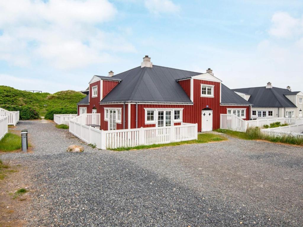 a red house with a black roof at 4 star holiday home in Ringkøbing in Ringkøbing