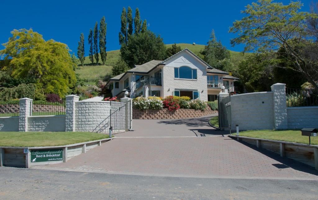 a house with a fence and a driveway at Llanerchymedd in Taihape