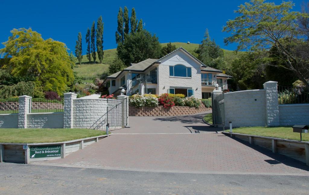 uma casa com uma cerca e uma entrada em Llanerchymedd em Taihape