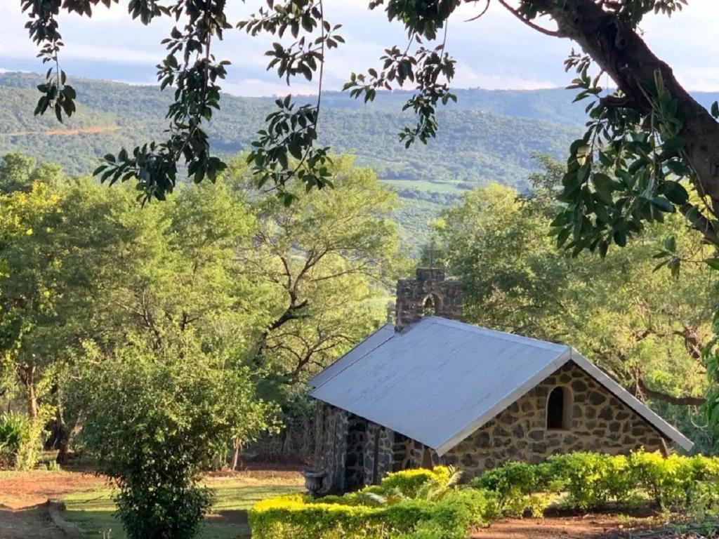 an old stone building with a white roof at Hazyview Accommodation, Bon Repose Cottage 2 in Hazyview