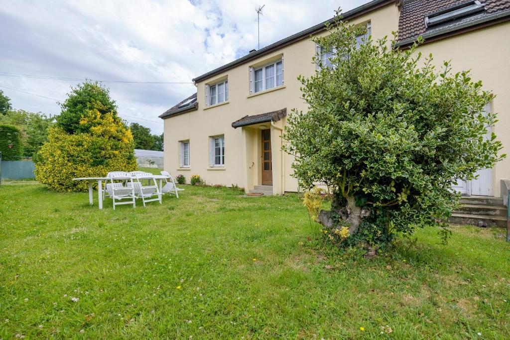a house with a picnic table in the yard at Gîte Chez Madeleine in Coutances