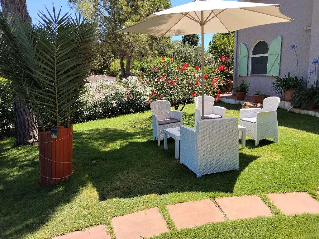 a patio with white chairs and an umbrella at Soberania in Pula