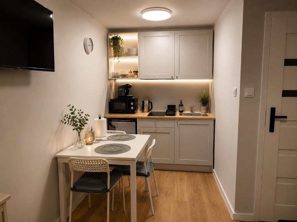a small kitchen with a white table and chairs at Róża Wiatrów Leśny Klif in Debina