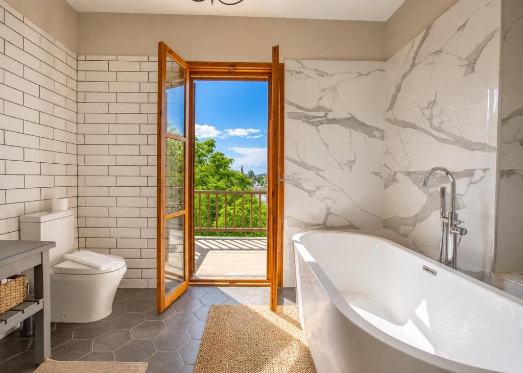 a bathroom with a tub and a toilet and a window at Casablanca Villa by HolidayKeys in Kyrenia