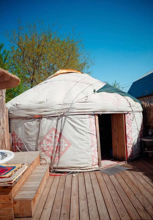 a white tent sitting on a wooden deck at Юрта в аренду in Almaty