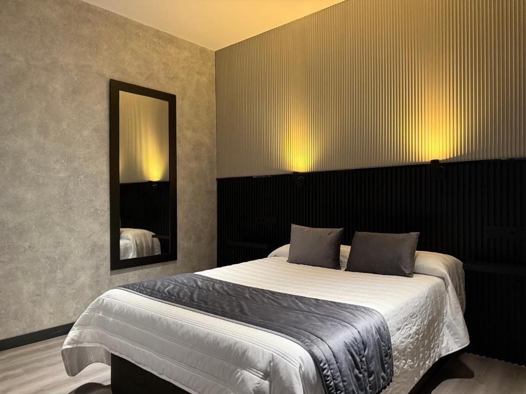 ein Schlafzimmer mit einem großen Bett und einem Spiegel in der Unterkunft Hotel Reset in Madrid