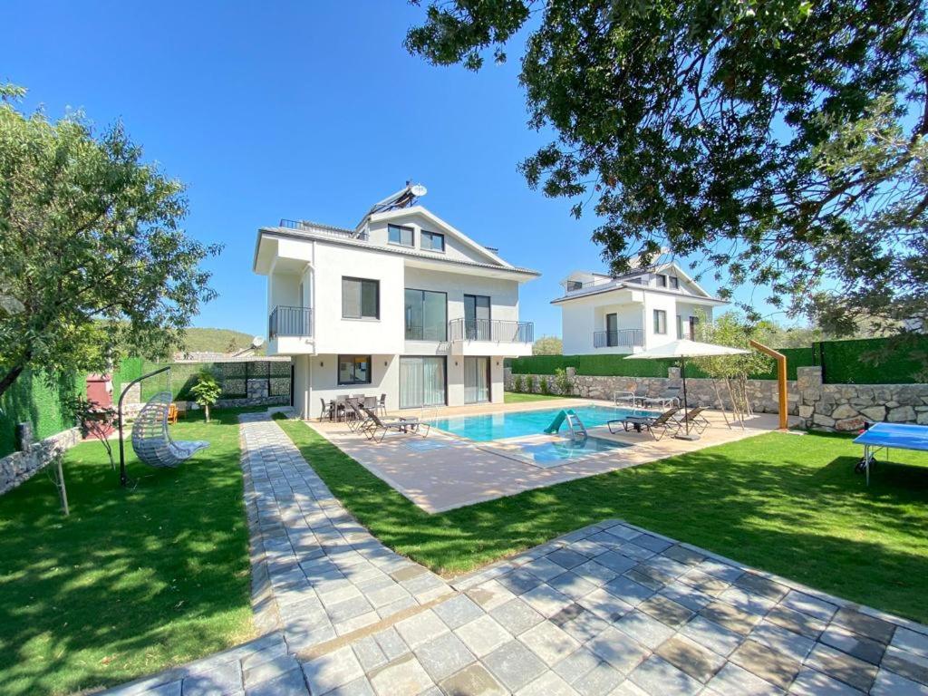 a large white house with a swimming pool at Villa Sasadi in Fethiye