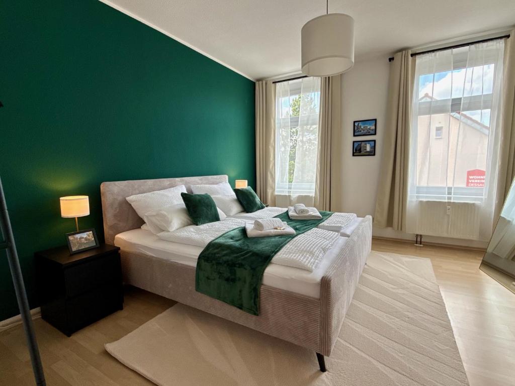 a bedroom with a green wall and a bed at Stilvolles Apartment Eigenständiger Check-in in Dessau
