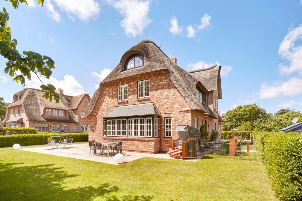 a large brick house with a gambrel roof at Reethus Nordstil in Borgsum