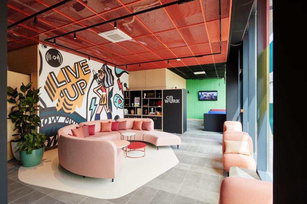 a living room with a couch and a table and chairs at Hife Toulouse Sud Labège in Labège
