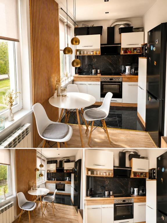 a kitchen with black and white appliances and a table and chairs at Kamienica Centrum in Pisz