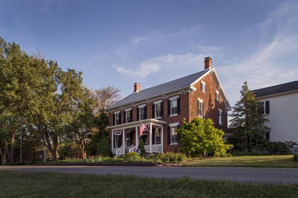 a red brick house with a flag on it at Pheasant Field Bed and Breakfast in Carlisle