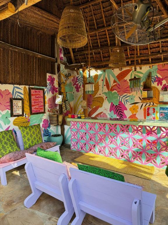 a room with a bench and a colorful wall at FURAHA GARDEN Rooms in Kendwa