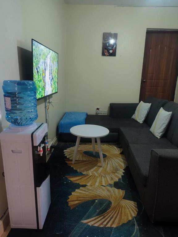 a living room with a couch and a table at Bnb kamakis in Ruiru
