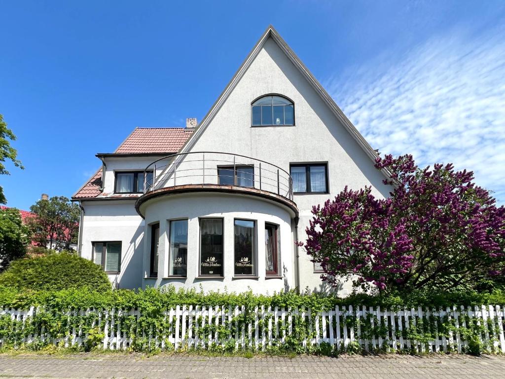a white house with a white picket fence at Seedri Guesthouse in Pärnu