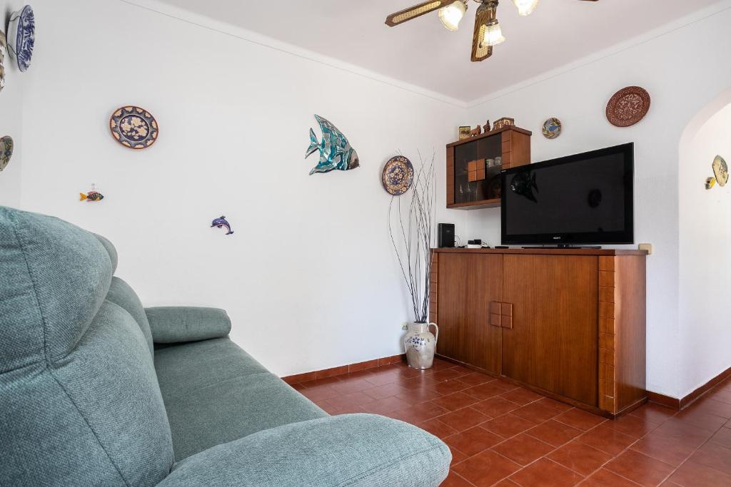 a living room with a couch and a flat screen tv at Apartamento Vargas in Monte Gordo