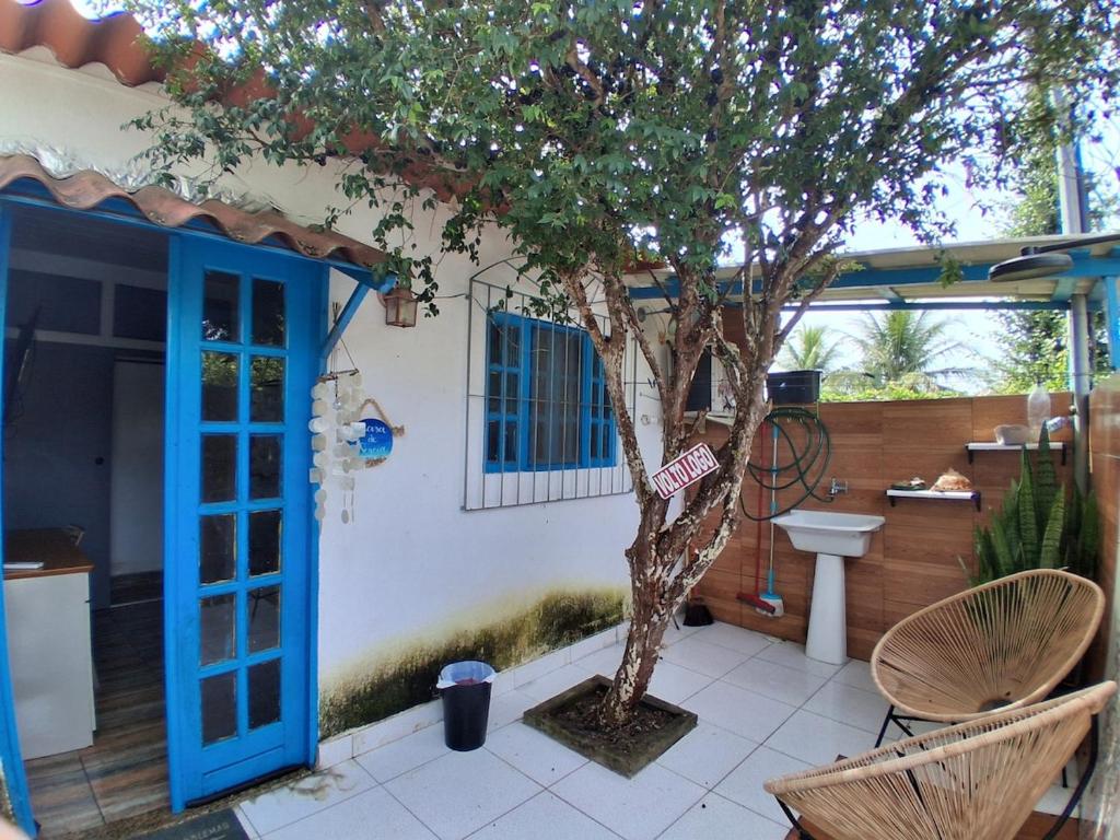a small tree in front of a house with a blue door at Santa Monica Beach Tiny House in Guarapari