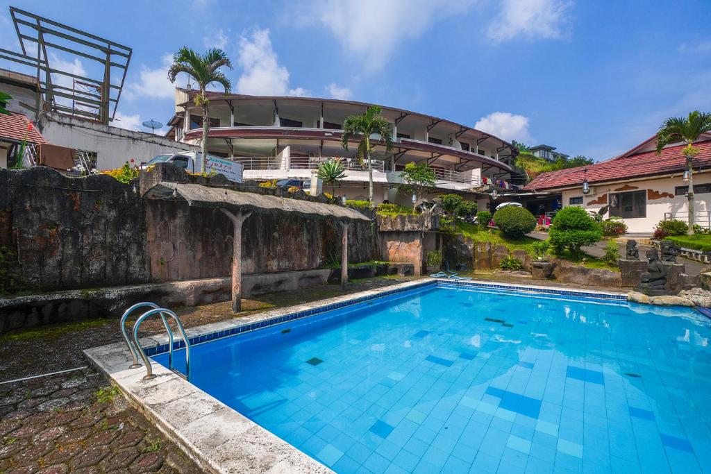 a large blue swimming pool in front of a building at Villa Tjokro 1 By ARBA in Sampal 2