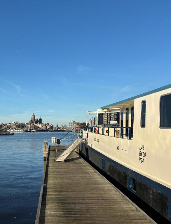 a boat is docked at a dock next to the water at Hotelboat Iris in Amsterdam