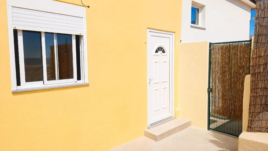 a yellow house with a white door and windows at DomusCavadas in Porto