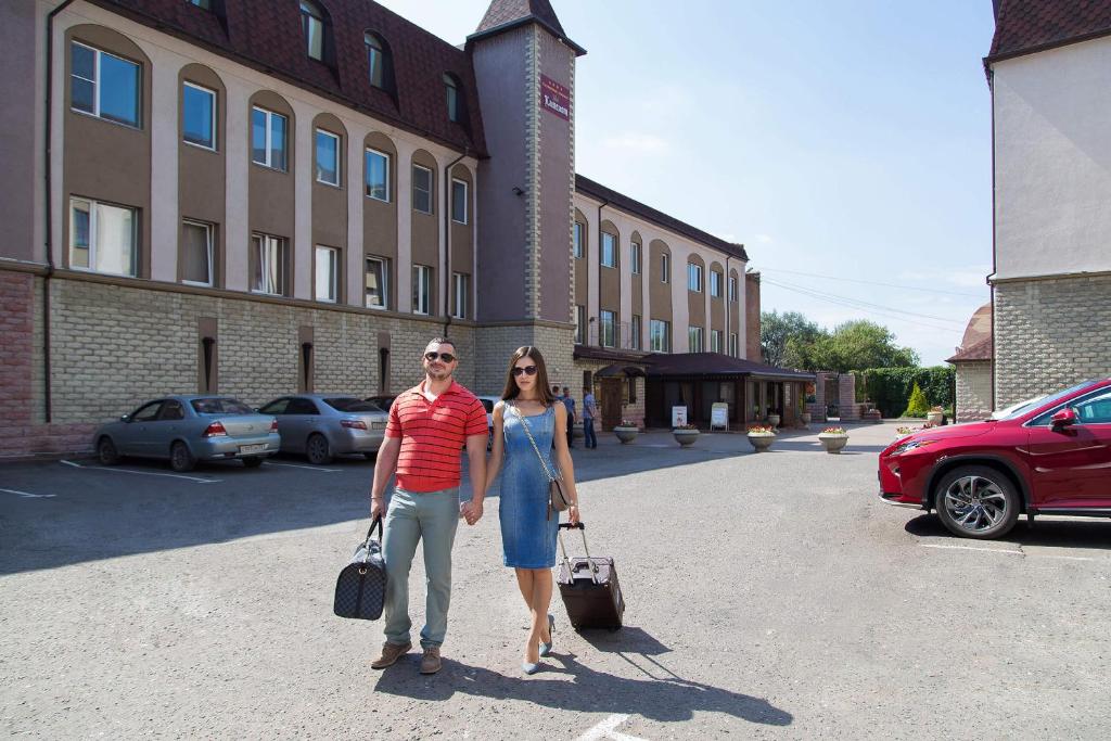 a man and a woman standing in front of a building at Hotel Kamelot in Omsk