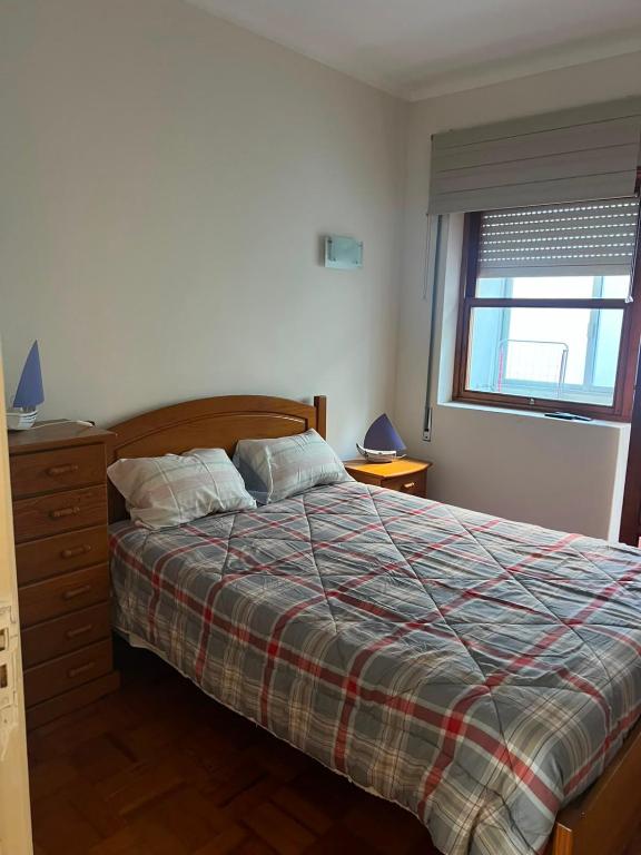 a bedroom with a bed and a window at Sol e Praia in Figueira da Foz