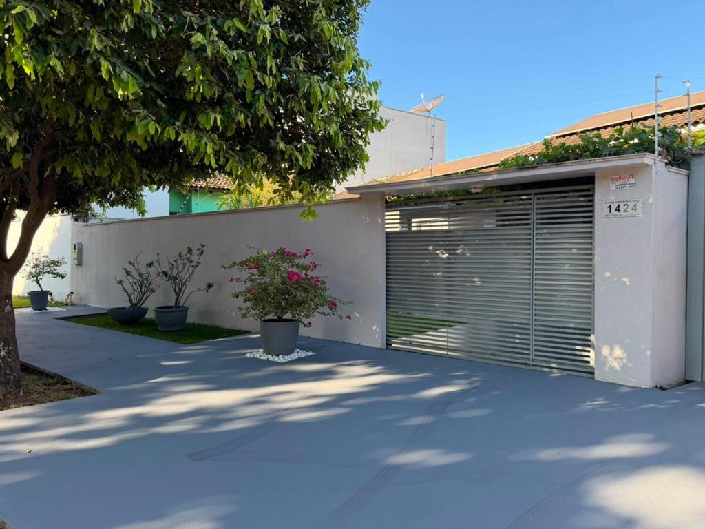 a building with a garage door and a tree at Casa completa 3 quartos in Sinop