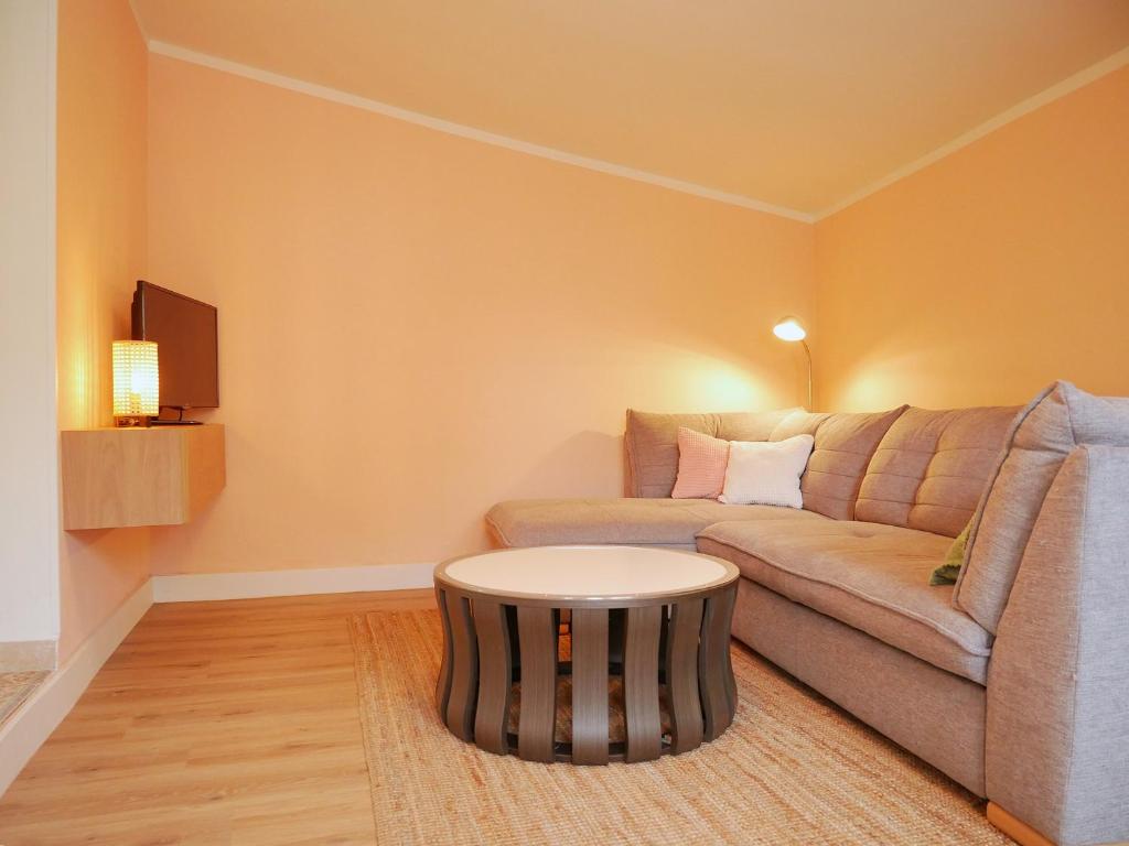 a living room with a couch and a table at Hafen Bungalow in Kirchdorf