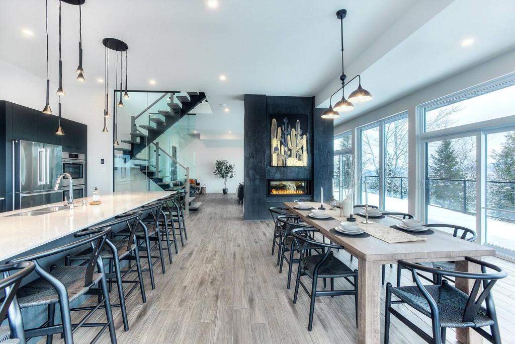 a kitchen and dining room with a long table and chairs at Tremblant Summit: Travel Experience Beyond Compare in La Conception