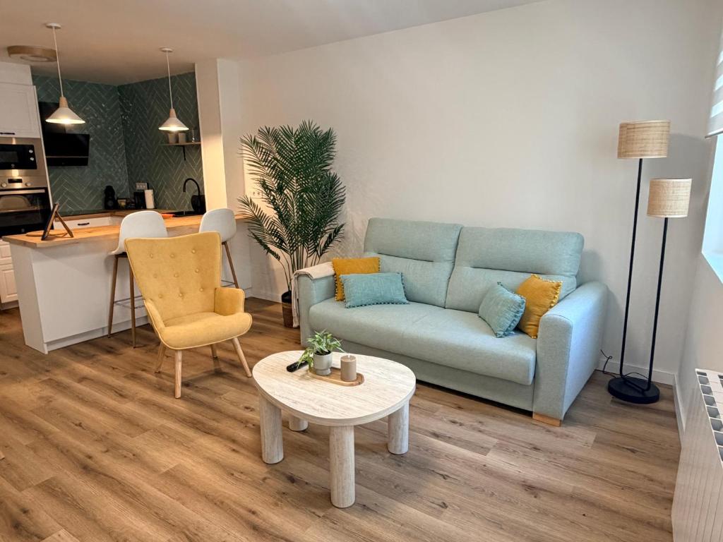 a living room with a blue couch and a table at El rincón de armanyá in Lugo