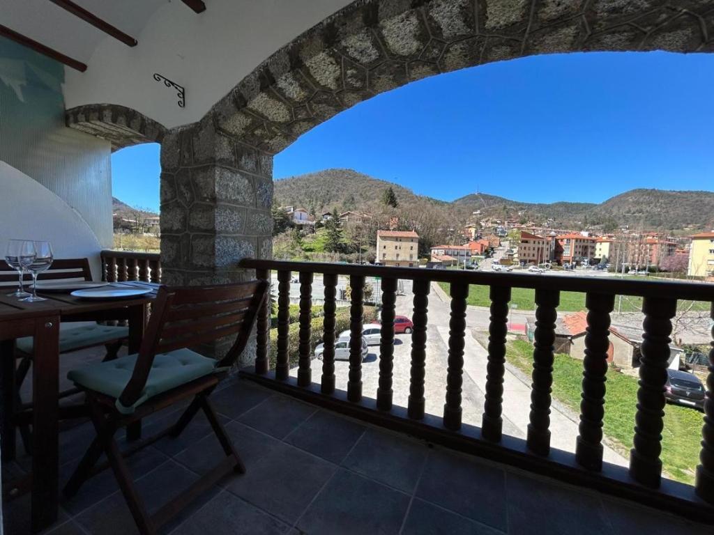 a room with a balcony with a table and a view at Cal Botey in Ripoll