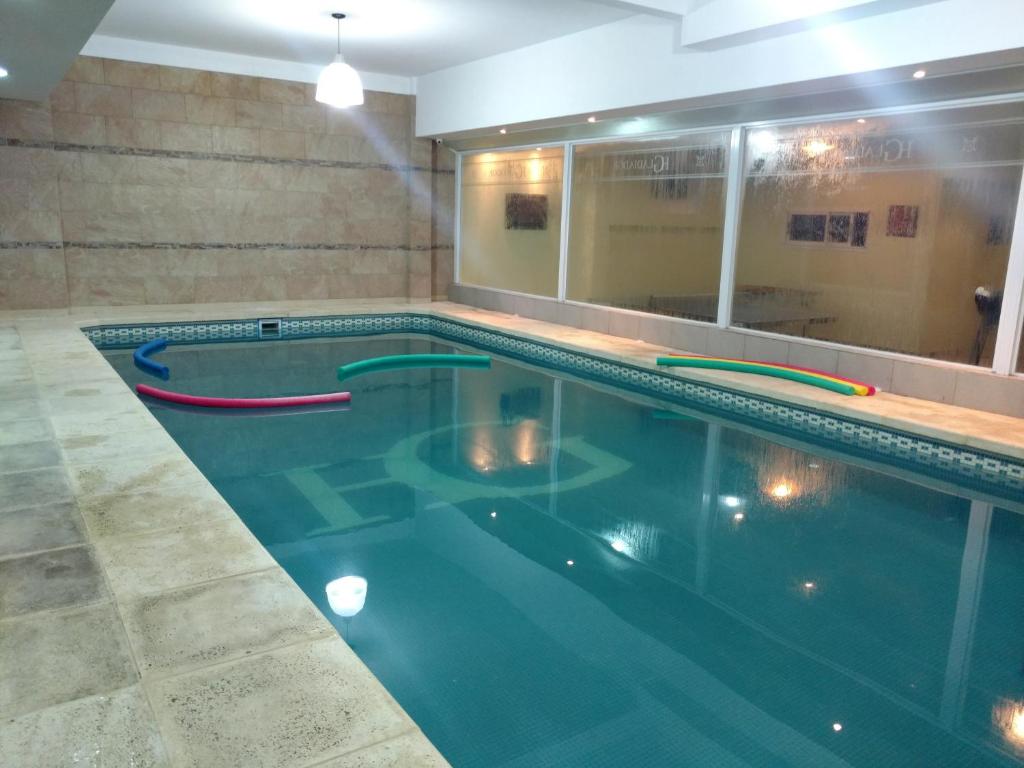 a swimming pool with blue water in a building at Hotel Gladiador in San Bernardo