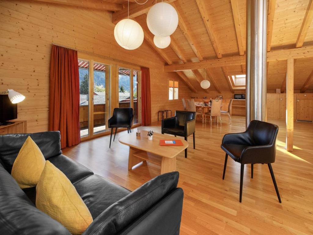 a living room with a couch and chairs and a table at Apartment Chalet Almisgässli by Interhome in Grindelwald