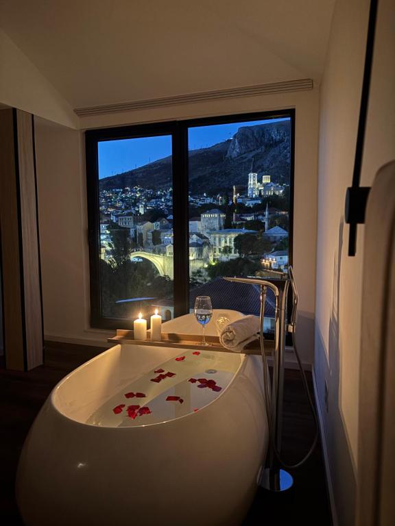a bath tub in a room with a large window at Villa Anri in Mostar