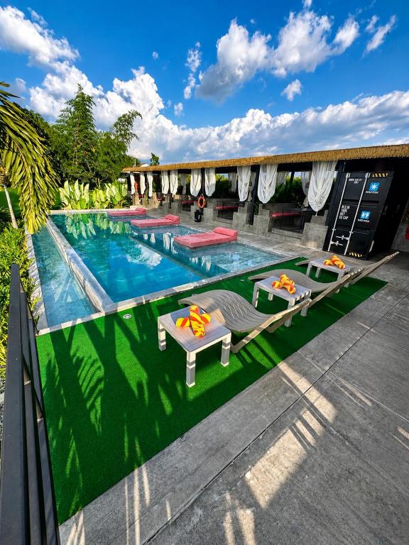 a swimming pool with tables and chairs on a patio at Eco Hotel La Colina Mirador Con aire acondicionado in Quimbaya