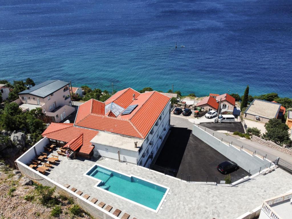 an aerial view of a house with a swimming pool and the ocean at Apartment Delfin-3 by Interhome in Cesarica