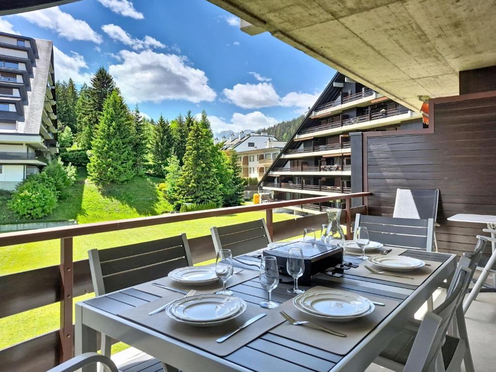 a dining table on the balcony of a house at Apartment Victoria C 8 by Interhome in Crans-Montana