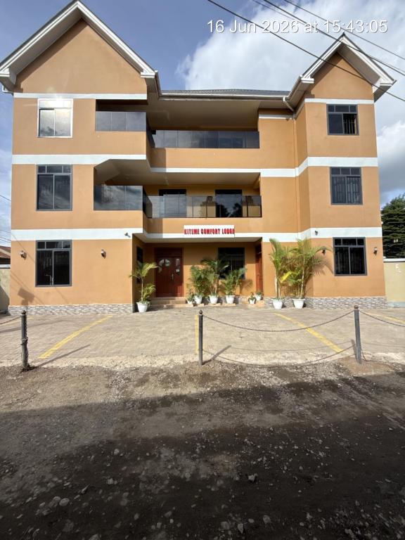 a building with a parking lot in front of it at Kiteme Comfort Lodge in Arusha