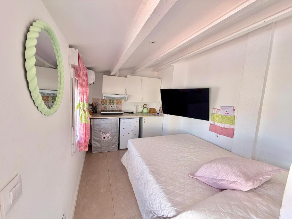 a small bedroom with a bed and a kitchen at Habitación con baño y cocina in Caudiel