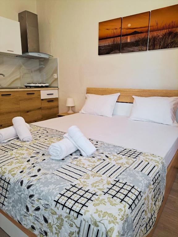 a bedroom with a large bed with towels on it at Maria's Garden Studio in Sarti