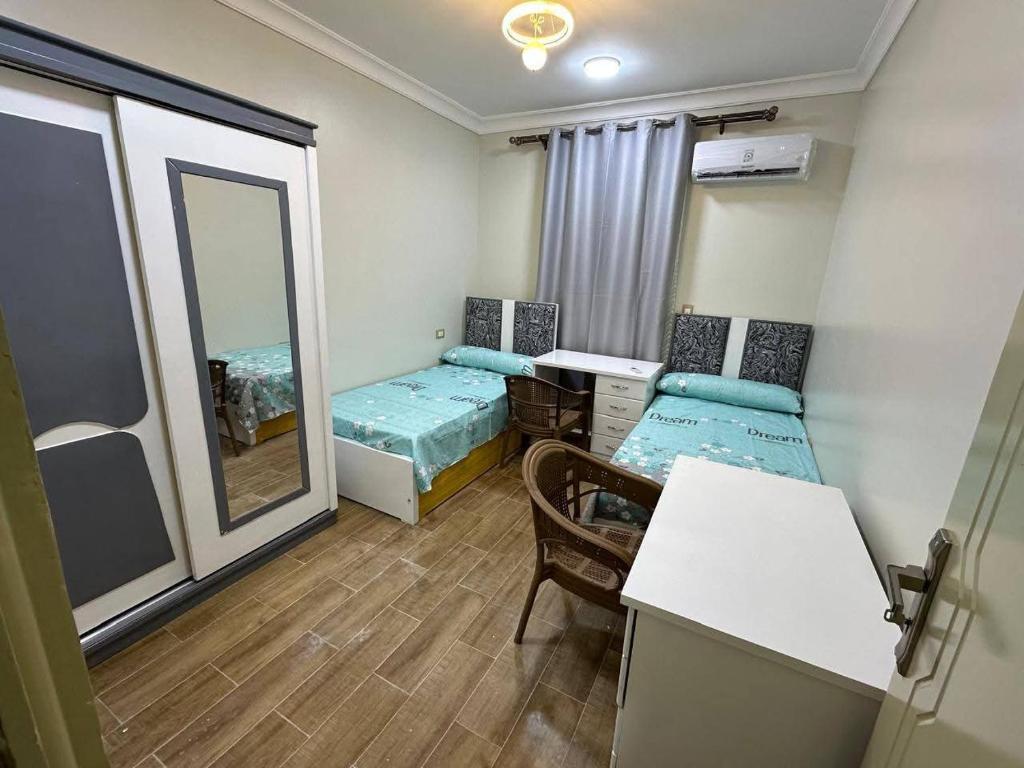 a small room with two beds and a mirror at Um yousef house in Alexandria