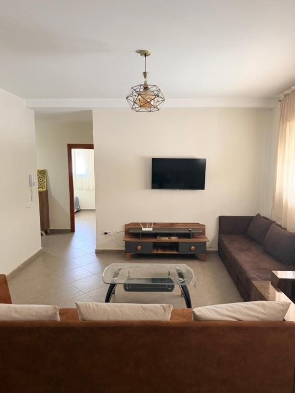 a living room with a couch and a flat screen tv at Location meublée Martil in Martil