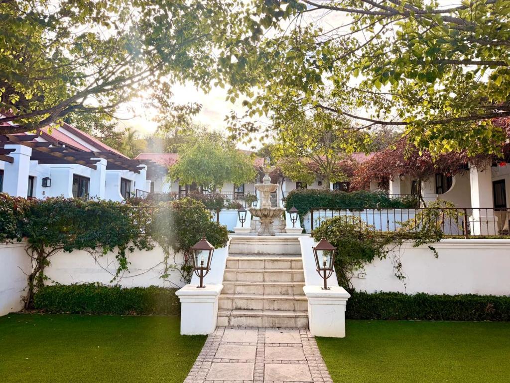a fountain in the middle of a yard with houses at Homestead Villas in Bellville