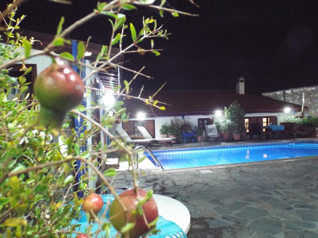 una casa con piscina por la noche en The Pomegranate's House, en Ephtagonia